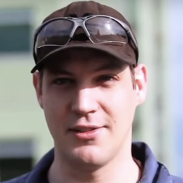 A young man wearing a ballcap with safety goggles resting on it